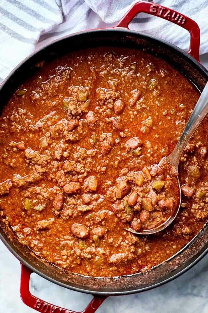 The Best Beef Chili Recipe with ground beef and beans in stockpot with ladle foodiecrush.com