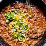 The Best Beef Chili Recipe with ground beef and beans and cheese and jalapenos in stockpot with ladle foodiecrush.com